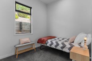 - une chambre avec un lit, une chaise et une fenêtre dans l'établissement Fuel for the Sol - Mangawhai Heads Holiday Home, à Mangawhai