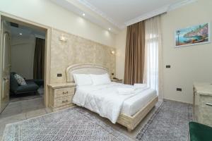 een slaapkamer met een groot wit bed in een kamer bij Olimpic Hotel in Tirana