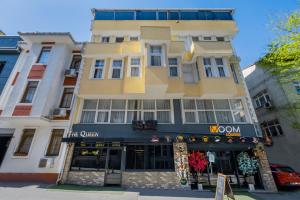a tall yellow building with a store front at The Queen Hotel in Istanbul