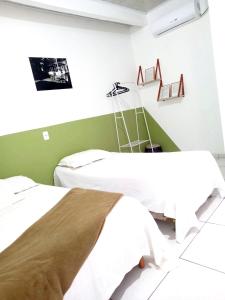- 2 lits dans une chambre de couleur verte et blanche dans l'établissement Chaves Maguari Locação por Temporada- Ananindeua, à Ananindeua
