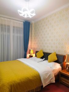 um quarto com uma cama amarela com almofadas amarelas em Mama Naxi Guesthouse em Lijiang