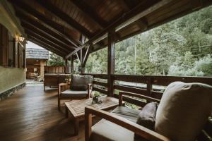 a screened in porch with chairs and a table at Charming Slovenia - Herbal Glamping Resort Ljubno in Ljubno