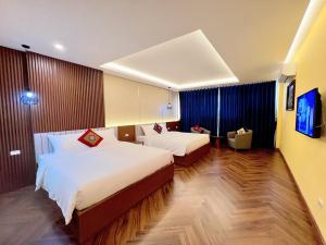 a hotel room with two beds and a tv at An Khang Hotel Sapa in Sapa