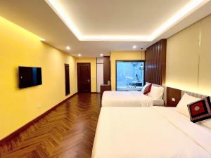 a hotel room with two beds and a television at An Khang Hotel Sapa in Sapa