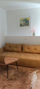 Guest House Klaudija في تروغير: أريكة بنية في غرفة المعيشة مع طاولة