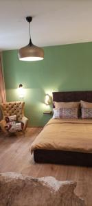Un dormitorio con una cama grande y una pared verde en Guest House Klaudija, en Trogir