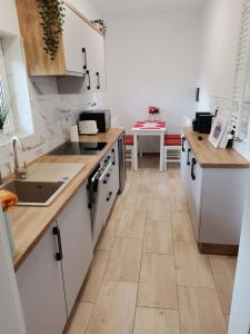 a kitchen with white cabinets and a tile floor at Apartament nad wodą 2 in Marzęcino