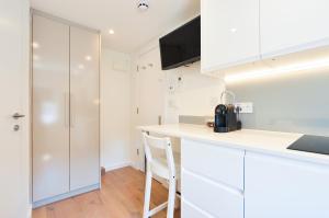 a kitchen with white cabinets and a counter top at Regents Serviced Apartments by StayPrime in London
