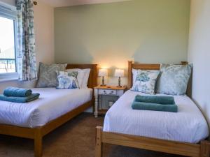 a bedroom with two beds and a window at Low Chibburn Farm Cottage in Hadston