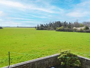 ein großes, grünes Gras mit einem Zaun in der Unterkunft Low Chibburn Farm Cottage in Hadston