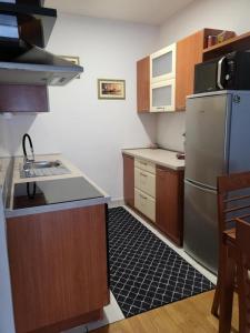 a kitchen with wooden cabinets and a stainless steel refrigerator at Apartment Tonci Vrbani in Zagreb