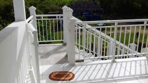 une clôture blanche avec un panier en osier sur une terrasse couverte dans l'établissement Appartement de 2 chambres avec balcon et wifi a Petit Canal a 4 km de la plage, à Petit-Canal