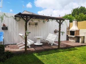 a patio with two white benches and a gazebo at Charming House in Esteiro with Garden and Terraces in Esteiro