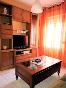 a living room with a coffee table and a tv at Charming House in Esteiro with Garden and Terraces in Esteiro