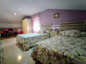 a bedroom with two beds and a purple wall at Charming House in Esteiro with Garden and Terraces in Esteiro +27 photos