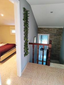 a living room with a bed and a plant on the wall at Charming House in Esteiro with Garden and Terraces in Esteiro