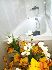 a bouquet of flowers sitting in a bath tub at Charming House in Esteiro with Garden and Terraces in Esteiro
