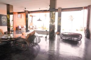 um átrio com cadeiras, uma mesa e um sofá em 4 bedrooms villa with sea view private pool and furnished garden at Kabupaten de Tabanan em Antasari