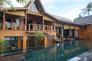 a house with a swimming pool in front of it at 4 bedrooms villa with sea view private pool and furnished garden at Kabupaten de Tabanan in Antasari
