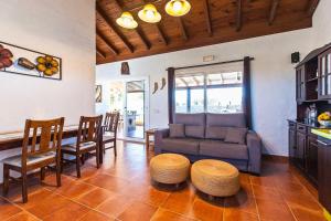 コティージョにある2 bedrooms villa with sea view private pool and jacuzzi at El Roque 1 km away from the beachのリビングルーム(ソファ、テーブル、椅子付)