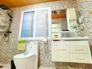 a bathroom with a toilet and a window at Mama Naxi Guesthouse in Lijiang