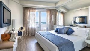 una camera d'albergo con un grande letto con cuscini blu di Hotel Nautico a Riccione