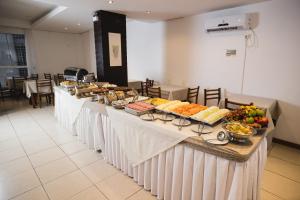 uma linha de buffet com muitos tipos diferentes de alimentos em Luisa Palace Hotel em Florianópolis