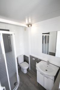 La salle de bains blanche est pourvue de toilettes et d'un lavabo. dans l'établissement 2 bedrooms appartement at Puerto de Pollenca 100 m away from the beach with sea view jacuzzi and furnished terrace, à Port de Pollença