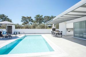 una piscina con patio e una casa di VillaPhysis with Private Pool a Lárdos