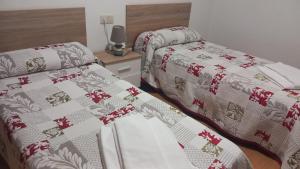 カルダス・デ・レイスにあるAlojamiento Caldas de Reisのベッドルーム1室(隣り合わせのベッド2台付)