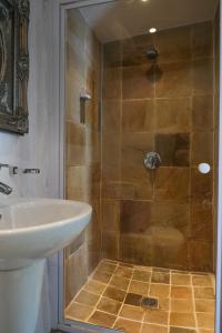 a bathroom with a shower and a sink at Old Potters Inn in Greyton