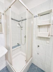uma casa de banho branca com um chuveiro e um lavatório. em Charming 3 Bedrooms Near Vienna Central Station Apartment em Viena