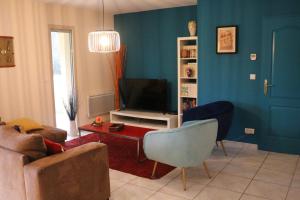 a living room with a couch and a television at Le Camp De Ferie in Monpazier