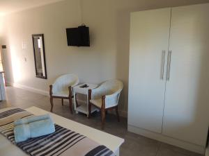 a bedroom with a table and chairs and a tv at Sand Dollar @ The Dunes in Plettenberg Bay