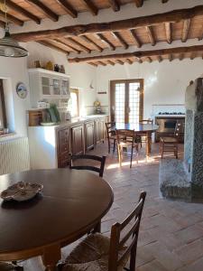eine Küche und ein Esszimmer mit einem Tisch und Stühlen in der Unterkunft Casale Eclissi in Bagnaia