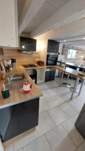 uma cozinha com um lavatório e uma bancada em Appartement Duplex avec jardin em Rodez