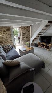 uma sala de estar com uma cama e uma televisão em Appartement Duplex avec jardin em Rodez