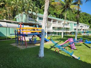 a playground in front of a building with palm trees at AP ALECRIM Luxo Cond Aquarius I Angra dos Reis in Angra dos Reis