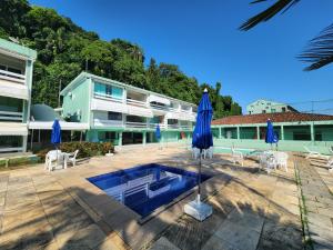 a resort with a pool and chairs and umbrellas at AP ALECRIM Luxo Cond Aquarius I Angra dos Reis in Angra dos Reis