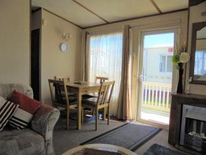 a living room with a table and chairs and a fireplace at 6 Berth on Golden Sands (Celebration) in Ingoldmells