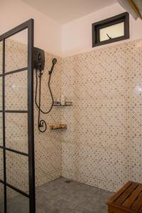eine Dusche in einem Zimmer mit einer Wand mit Fliesen in der Unterkunft Spacious fancy house/centrally located in Hinkong