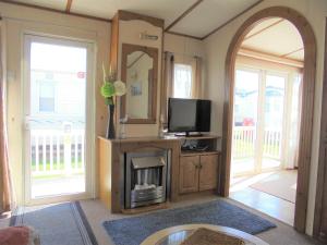 a living room with a fireplace and a tv at 6 Berth on Golden Sands (Celebration) in Ingoldmells