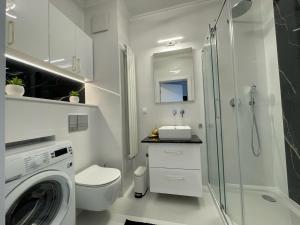 y baño con lavadora y ducha. en Apartament przy Marsa, en Varsovia 2 fotos más