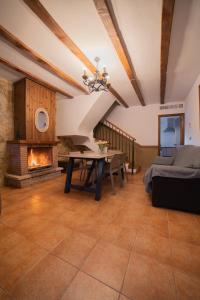 sala de estar con mesa y chimenea en Casas Rurales Los Olivos, en Alcalá del Júcar