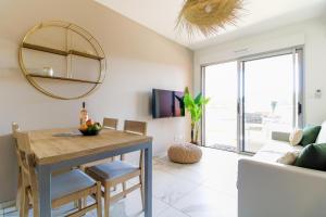 ein Wohnzimmer mit einem Tisch und einem Spiegel in der Unterkunft SELECT SO HOME - Magnifique appartement dans une résidence avec piscine et à proximité des plages - POS35 in Bormes-les-Mimosas