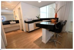 a kitchen with a black counter and a table and chairs at IT Itabira Hotel in Itabira