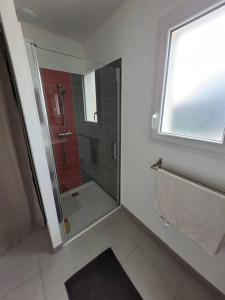 ein Bad mit einer Dusche, einem Waschbecken und einem Fenster in der Unterkunft Maison de ville neuve in Les Essarts