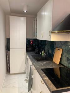 kuchnia z białymi szafkami i czarnym blatem w obiekcie Tabago Studio 6 w mieście Katowice