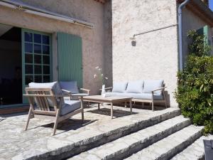 dwa krzesła i stół na patio w obiekcie Villa VUE MER plage de La FOSSETTE 5mn à pied Proche du Centre w mieście Le Lavandou +25 zdjęć
