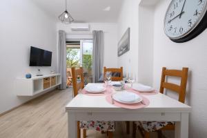 ein Esszimmer mit einem Tisch und einer Uhr an der Wand in der Unterkunft Apartment Terrazzo in Rijeka